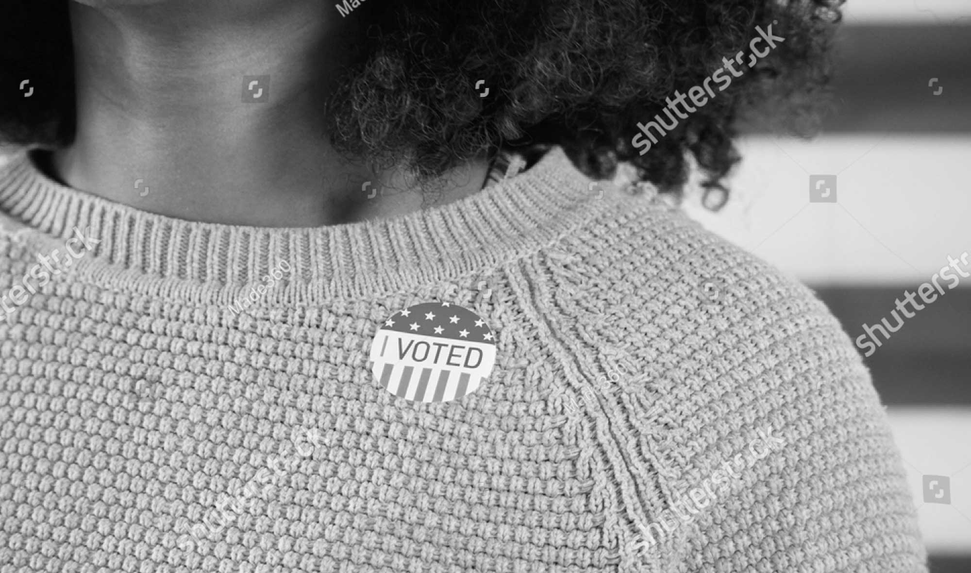 cropped picture of woman's sweater with an I Voted sticker affixed to it